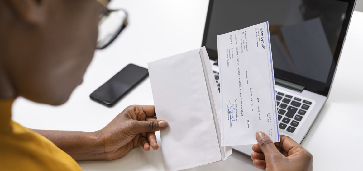 woman removing cashiers check from envelope