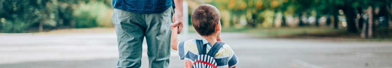 Father and son walking with backpack.