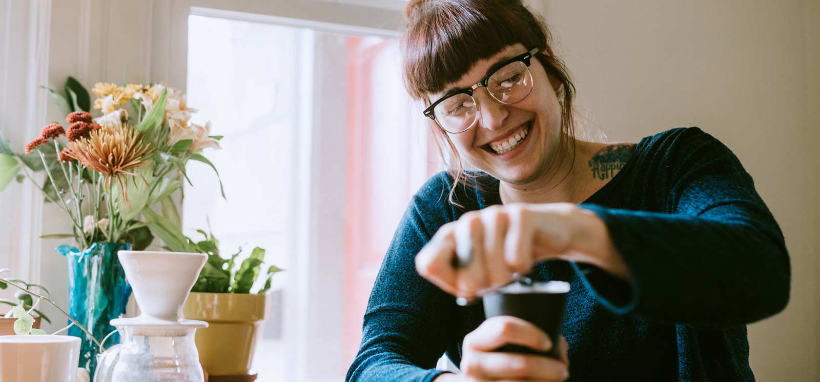 Woman at home with coffee smiling.